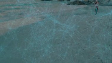 Sahilde bisiklet süren ve ağ bağlantıları olan biri. Bisiklet, dijital, teknoloji, iletişim, yaz mevsimi