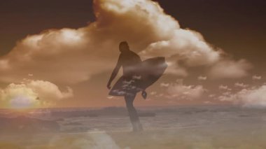 Gün batımında, sörfçü silueti elinde okyanus dalgaları ve bulutlarla sörf tahtası tutuyor. Sörf, sahil, macera, rahatlık, sükunet.