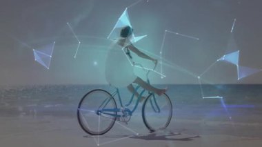 Sahilde bisiklete binen kadın dijital dünya animasyonu ile örtüşüyor. Bisiklet, teknoloji, fütüristik, sanal, yaşam tarzı, macera