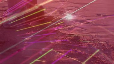 Sahilde meditasyon yapan, renkli animasyon ışık çizgileriyle çevrili biri. Meditasyon, sükunet, rahatlama, farkındalık, dinginlik, uyum.