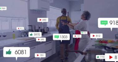 Mutfakta dans eden, sosyal medya bildirimli yaşlı bir çift. Aile, mutluluk, teknoloji, bağlantılar, aşk, nesiller arası