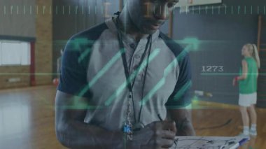 Basketbol antrenmanından sonra veri işleme animasyonuyla spor salonunda koç. Spor koçluğu, analiz, teknoloji, performans, dijital kaplama, fitness