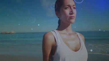 Sahilde dikilen, dijital ağ ile etkileşime giren bir kadın yaz kıyafetleri içinde. Teknoloji, ağ, bağlantı, iletişim, sanal, tatil