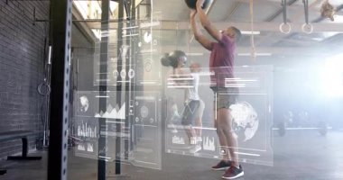 Spor salonunda egzersiz yapan, dijital animasyon veri grafikleri üst üste binen iki kişi. Fitness, egzersiz, teknoloji, sanal, artırılmış gerçeklik, sağlık