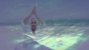 Okyanus arka planında dijital veri animasyonuyla yoga yapan yaşlı kadın. Meditasyon, sağlık, teknoloji, dinginlik, görselleştirme, rahatlama