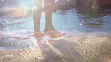 Dijital ağ animasyonu ile kumlu sahilde yürüyen çıplak ayaklar. Teknoloji, rahatlama, tatil, okyanus, boş zaman, bağlantı