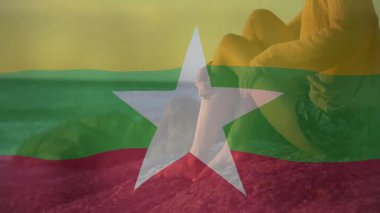 Okyanusun kenarında oturmuş, Myanmar bayrak animasyonuyla rahatlayan biri sahne hazırlıyor. Seyahat, rahatlama, dinginlik, meditasyon, doğa, turizm