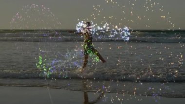 Sahne boyunca renkli parıltılı animasyonlarla okyanus dalgalarından hoşlanan bir kadın. Plaj, tatil, dinlenme, deniz, tropikal, boş zaman