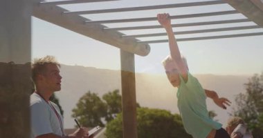 Parmaklıklarda oynamak, başka bir çocuk parkı izlerken çocuk sahibi olmak. çocukluk, aktivite, eğlence, eğlence, çocuklar, açık hava