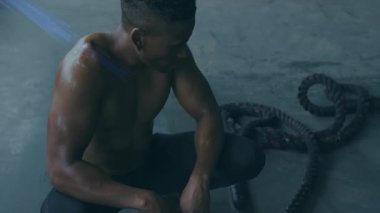 Yerde oturan adam animasyondaki mavi ışık huzmeleriyle çevrili. Teknoloji, dijital, fütürist, yenilik, sanal, neon