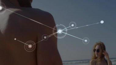 Kumsaldaki insanlar üzerinde bağlantı ağı ve veri işleme animasyonu. Teknoloji, bağlantı, dijital, yenilik, iletişim, sanal