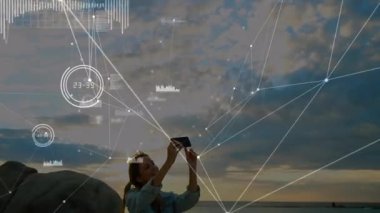 Dijital ağ animasyonuyla deniz kenarına oturmuş bir kadın. Teknoloji, bağlantı, yenilik, gelecek, görselleştirme, soyut