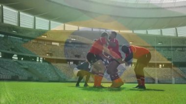 Stadyumda, rugby oyuncuları Brezilya bayrak animasyonu eşliğinde takım arkadaşlarını kaldırıyorlar. Sportmenlik, takım çalışması, rekabet, sporcular, kutlama, zafer