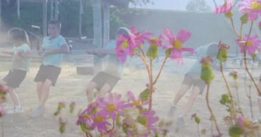 Okulda, çocuklar canlı pembe çiçeklerle çekiştirme oyunu oynuyorlardı. Çocuklar, takım çalışması, açık hava, eğlence, aktivite, doğa