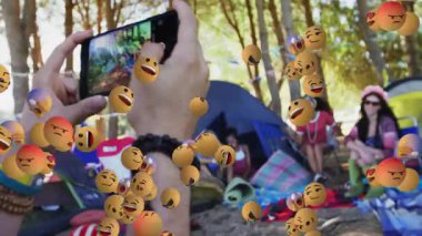 Ormanda kamp yapmak, yüzen emoji yüzleriyle çevrili insanlar, animasyon yaratmak. Açık hava, macera, teknoloji, yaratıcılık, dijital sanat