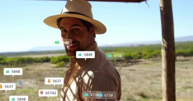 Açık havada şapka takan, sosyal medya animasyonları ve kalp ikonları olan bir adam. etkileşim, bağlantı, bağlılık, teknoloji, etkileyici, dijital