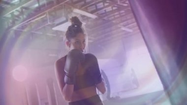 Spor salonunda yoğun bir şekilde antrenman yapan boks eldivenli kadın antrenmana odaklandı. Fitness, egzersiz, kararlılık, güç, motivasyon, atlet