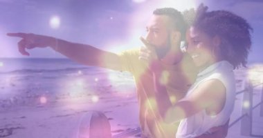 Okyanusu işaret eden, açık havada renkli ışık animasyonu yapan bir çift. Romantik, teknoloji, multimedya, canlı, ekran, etkileşim