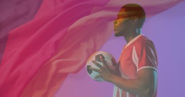 Futbol topunu tutan, animasyon arka planında pembe kumaşlı bir adam. Futbol, erkek, yaratıcılık, hareket, renkli, dinamik