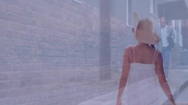 Brick caddesinde yürüyen, mayo giymiş bir kadın ve takım elbiseli bir adam. Moda, yaz, resmi, karşıtlık, kentsel, tarz