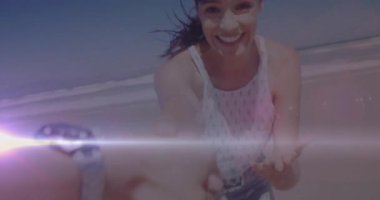 Kumsalda el ele tutuşan, ışık efektleriyle gülümseyen bir kadın. Romantik, tatil, günbatımı, mutluluk, çift, güneş ışığı