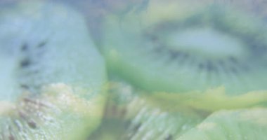 Canlı yeşil, dilimlenmiş kivi meyvesi ve animasyon dokusunun detaylarını gösteriyor. Tropikal, sulu