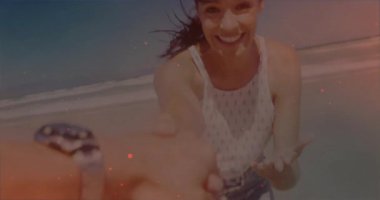 Kumsalda el ele tutuşmak, gülümseyen ve dalgaların animasyonundan zevk alan bir kadın. tatil, rahatlama, çift, mutluluk, okyanus, birliktelik