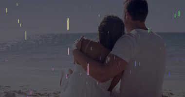 Sahilde kucaklaşan, renkli yıldız animasyon örtüsü olan çift, anın tadını çıkarıyor. Romantizm, günbatımı, kum, okyanus, boş zaman, birliktelik