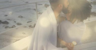 Samimi anları paylaşan, okyanus parmaklıklarına sarılmış bir çift. Romantizm, aşk, birliktelik, deniz manzarası, sıcaklık, sükunet