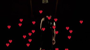 Çemberin altında duran basketbolcu, kırmızı kalplerle çevrili. Sporcu, sporcu, atletik, oyun, rekabet, romantizm