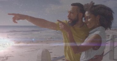 Sahilde, animasyon örtüsüyle gülümseyen bir çift, arka planda okyanus. Tatil, romantizm, deniz kenarı, mutluluk, boş zaman, tatil