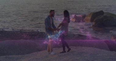 Pembe ve mavi renkli ışıltılı animasyon kaplamalı kumsalda el ele tutuşan çift. Romantik, gün batımı, birliktelik, tatil, yaz, aşk