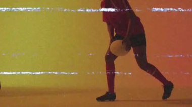Futbol topuyla diz çökmüş renkli arka planda animasyon efekti yapan bir sporcu. Spor, futbol, dinamik, enerji, hareket, canlı