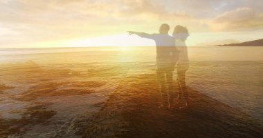 Mutlu bir Afrikalı Amerikalı çiftin deniz aşırı sahilde günbatımının keyfini çıkardığı bir görüntü. Doğa, mutlu tatiller ve dijital ortamda oluşturulan yaz imajı..