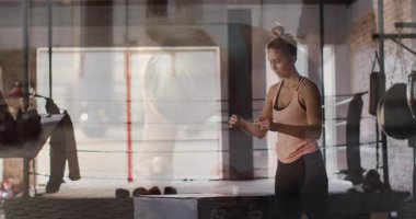 Spor salonunda egzersiz yapan, arka planda odaklanmış yüzü olan bir kadın. Fitness, egzersiz, kararlılık, motivasyon, teknoloji, dijital