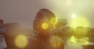 Kayalık suyun yanında duran kişi, animasyon sahnesinde parlayan ışıklarla çevrili. fantezi, macera, büyülü, aydınlatma, manzara, mistik