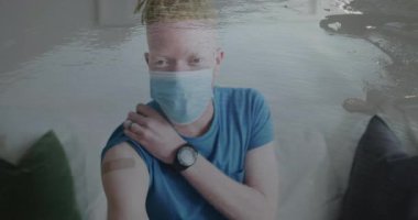Maske ve mavi gömlek giyen, okyanus dalgaları animasyonu olan biri. Sağlık, koruma, salgın, su, sükunet, grafikler