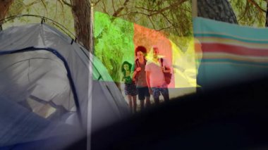 Kamp alanından geçen insanlar ağaçların üzerinde renkli bir animasyonla dolaşıyorlar. Doğa, kamp, açık hava, yürüyüş, macera, keşif