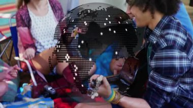 İnsanlar kamp alanında dijital dünya animasyonu eşliğinde müziği seviyorlar. Kamp ateşi, kamp, macera, teknoloji, sanal, açık hava