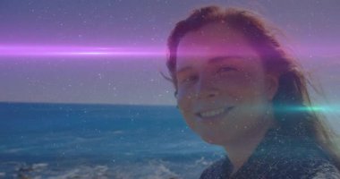 Sahilde, renkli ışığı olan kişi okyanus arka planında animasyon çizgiler çiziyor. Deniz kenarı, aydınlanma, gece vakti, canlı, huzur, huzur