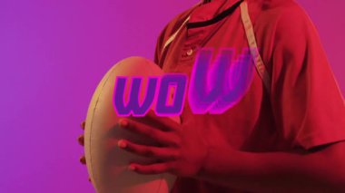 Kalın pembe harflerle yazılmış, rugby topu tutan, gülümseyen biri. Spor, takım çalışması, atlet, oyun, yarışma, coşku