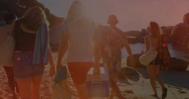 Soğutucu ve havlu taşımak, kumlu sahilde yürüyen bir grup insan. Tatil, yaz, tatil, gün ışığı, dinlenme, kıyı