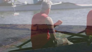 Suda kürek çeken, manzara animasyonu olan insanlar dinamik bir sahne yaratıyorlar. Takım çalışması, eğlence, açık hava.