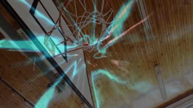 Basketbolcu renkli ışık izleriyle basketbolu potaya doğru fırlatıyor. Spor, atlet, aksiyon, hareket, enerji, dinamik