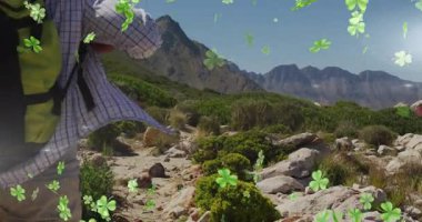 Sırt çantalı bir yürüyüşçü, dağ yolunda yonca animasyonu eşliğinde yürüyor. Yürüyüş, macera, doğa, açık hava, yürüyüş, keşif