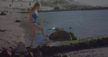 Kayalık kıyı şeridini keşfetmek, su üzerinde ışıldayan ışık animasyonuyla mayo giymiş bir kadın. Plaj, keşif, macera, doğa, tatil, kıyı şeridi