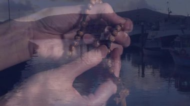 Ellerinde ahşap boncuklar ve alacakaranlık animasyonunda teknelerle durgun limana bakan eller vardı. Dinginlik, sükunet, meditasyon, sakinlik, alacakaranlık, rıhtım