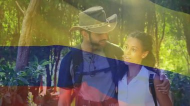 Ormanda yürüyüş yapan, animasyonda Kolombiya bayrağı taşıyan bir çift. Macera, doğa, sırt çantası, seyahat, keşif, açık hava