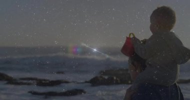 Sahilde, parlak animasyon efektleriyle yetişkin omuzlarında bir çocuk. Tatil, yaz, aile, neşe, okyanus, bağ