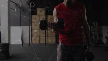 Kırmızı gömlekli adam ağ bağlantıları olan dambılları kaldırıyor. Fitness, egzersiz, teknoloji, yenilik, güç, dijital